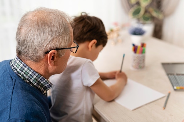 Gratis foto kleine jongen speelt met zijn grootvader