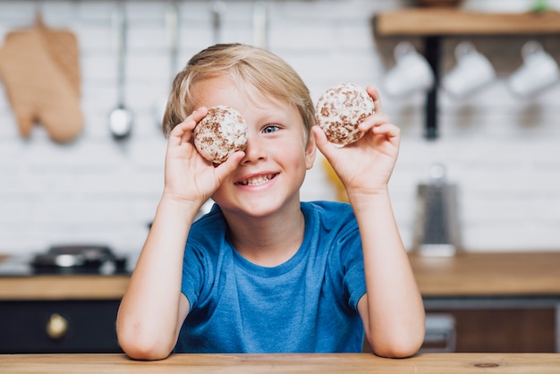 Gratis foto kleine jongen spelen met koekjes