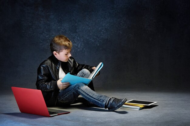 Kleine jongen zitten met gadgets