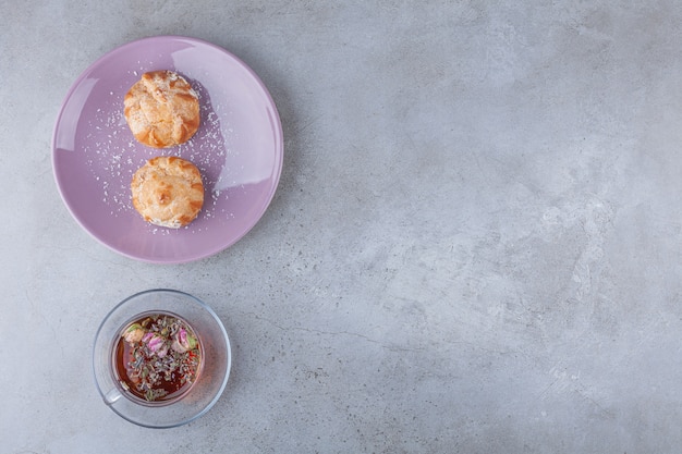 Kleine koekjes profitroles met suikerpoeder en kaneelstokjes.