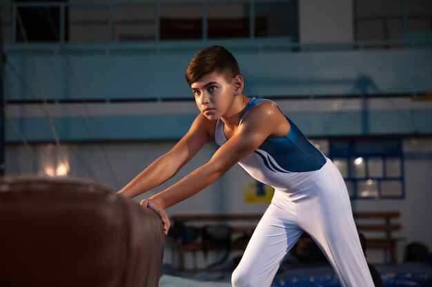 Kleine mannelijke turnster training in de sportschool