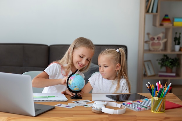 Kleine meisjes die thuis samen online school doen