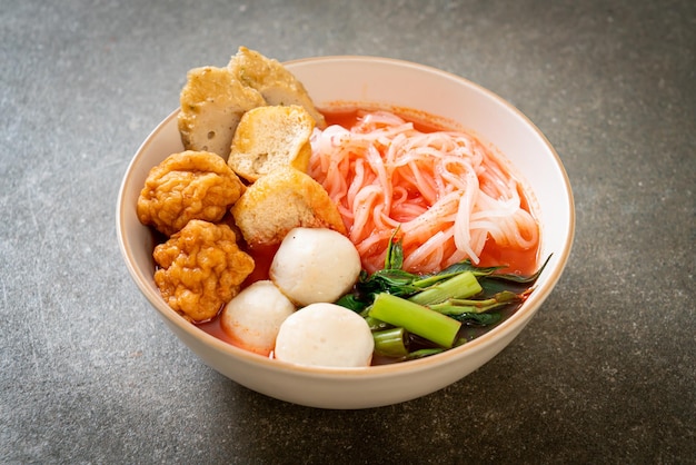 Kleine platte rijstnoedels met visballetjes en garnalenballetjes in roze soep, yen ta four of yen ta fo - asian food style