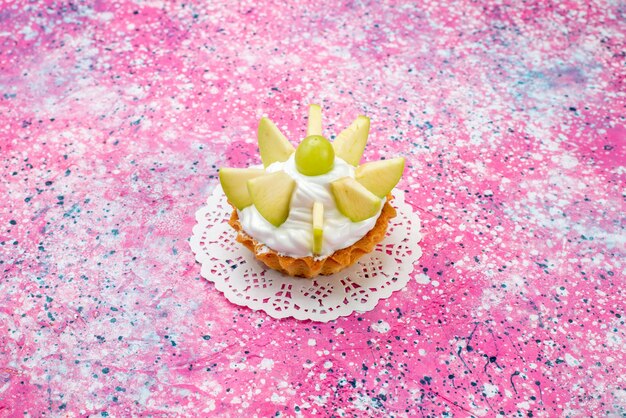 kleine romige cake met gesneden fruit op gekleurde, cake zoete suiker bak