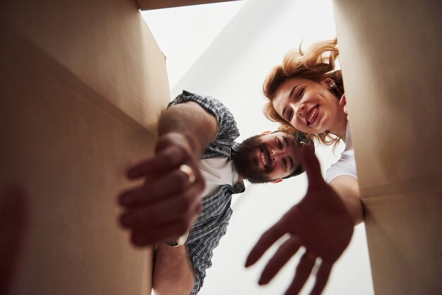 Kleren uit de doos halen. Gelukkig paar samen in hun nieuwe huis. Conceptie van verhuizen