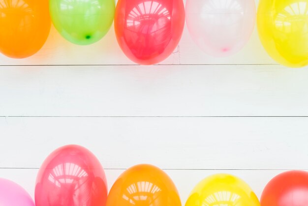 Kleurrijke ballonnen op houten witte tafel