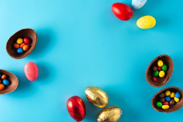 Kleurrijke chocolade paaseieren op blauwe achtergrond