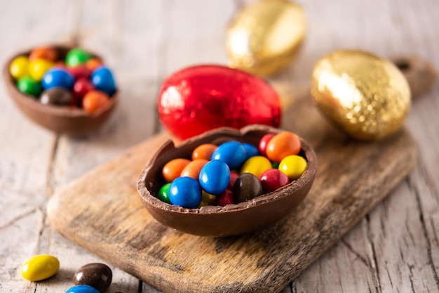 Kleurrijke chocolade paaseieren op houten tafel