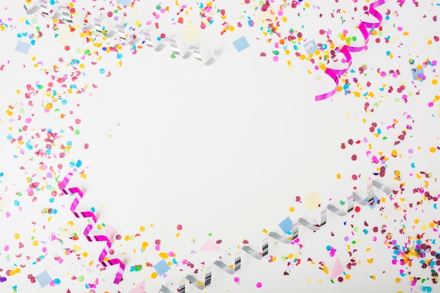 Gratis foto kleurrijke confetti en curling wimpels op witte achtergrond met ruimte voor tekst