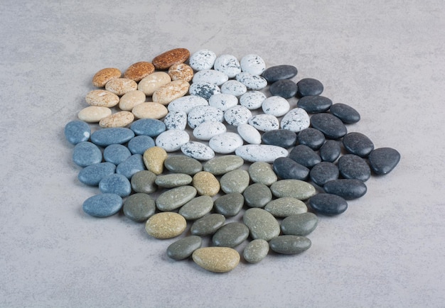 Kleurrijke decoratieve stenen voor het knutselen op een betonnen ondergrond.