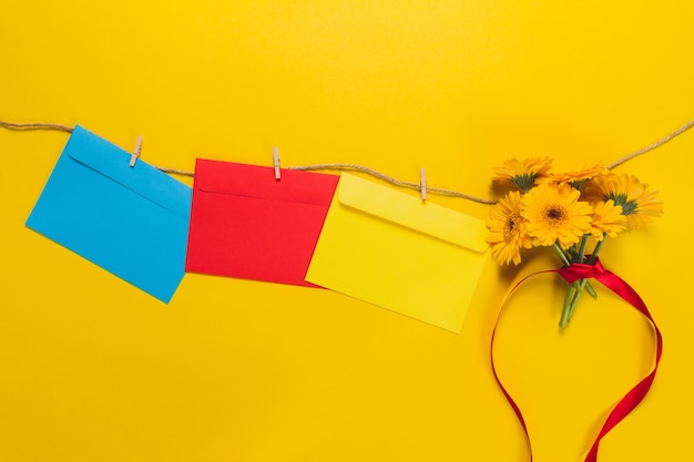 Kleurrijke enveloppen en bloemen opknoping