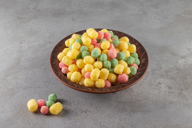 Gratis foto kleurrijke gezonde graangewassenballen die in een ceramische kom worden geplaatst.