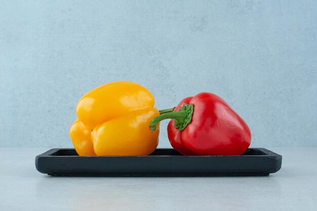 Kleurrijke groene paprika's op zwarte plaat.