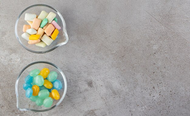 Kleurrijke kauwgom in kommen op een stenen tafel.