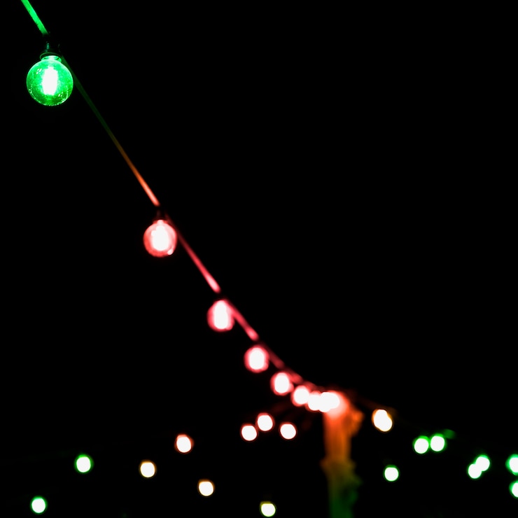 Gratis Foto kleurrijke kerstmis lichte decoratie tegen zwarte achtergrond
