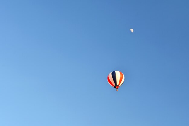 Kleurrijke luchtballon vliegen bij zonsondergang. Natuurlijke kleurrijke achtergrond met lucht.