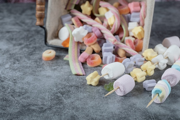 Kleurrijke marshmallows op de houten stokken om te grillen.