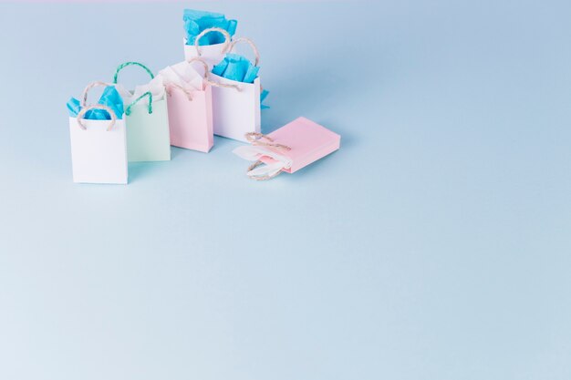 Kleurrijke papieren boodschappentassen op blauwe oppervlak