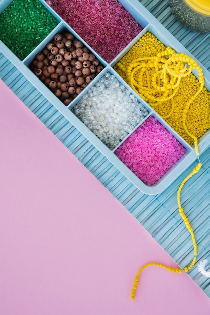 Kleurrijke parels in blauwe zaak op placemat over de roze achtergrond