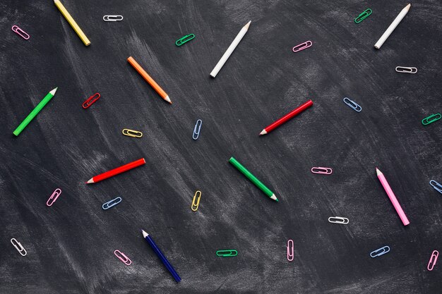 Kleurrijke potloden en paperclips op blackboard