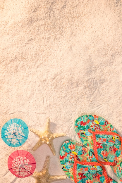 Gratis foto kleurrijke sandalen met zeester op strand