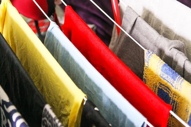 Kleurrijke verschillende kleding en wasgoed hangend aan een droogrek.