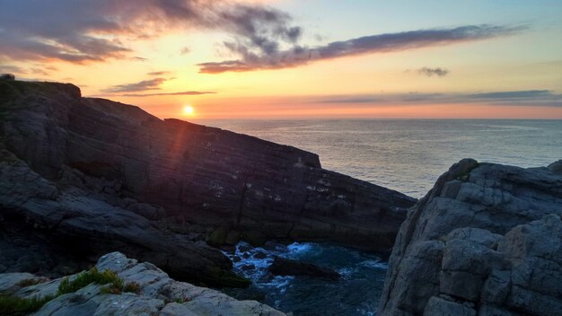 Kliffen omgeven door de zee onder het zonlicht tijdens de zonsondergang