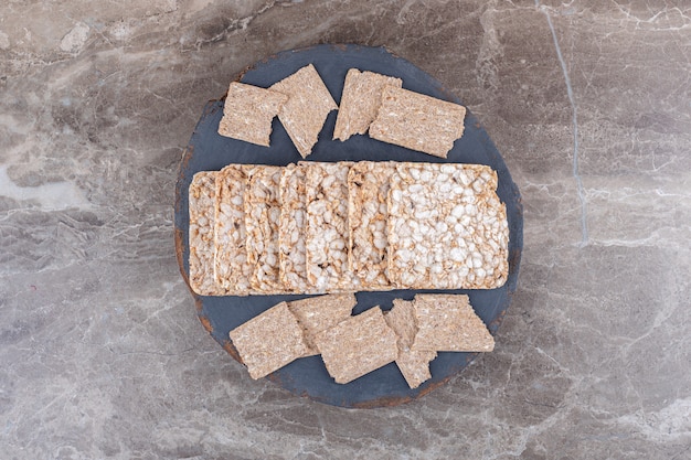 Knäckebröd en gepofte rijstwafels in bakje, op het marmeren oppervlak