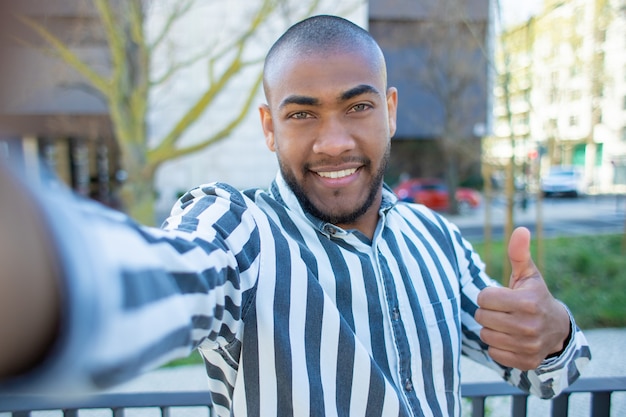 Knap glimlachend African American man duim opdagen