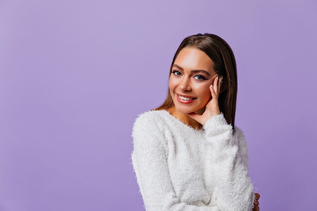 Knap, optimistisch meisje 25 jaar oud gelukkig. Portret van schattig model in peinzende pose, poseren op geïsoleerde muur