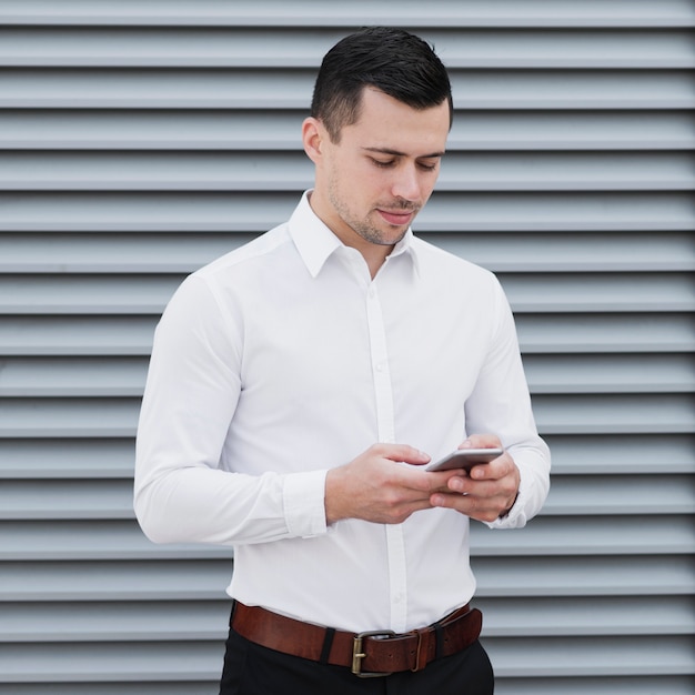 Knappe arbeider die telefoon controleert