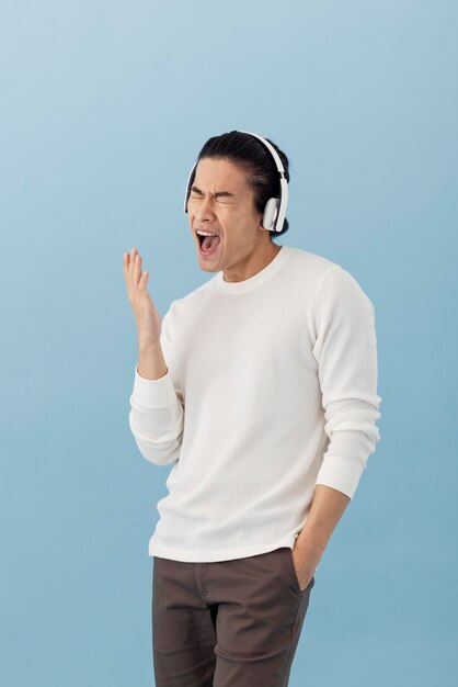 Knappe aziatische man die naar muziek luistert via een koptelefoon