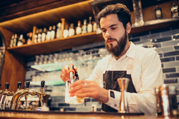 Knappe barman drinken en cocktails aan een balie maken