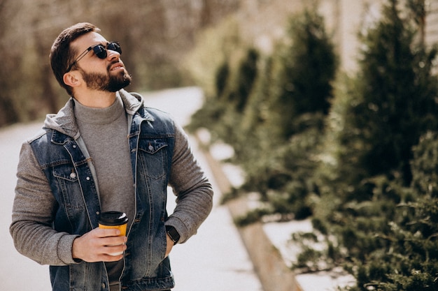 Knappe bebaarde man koffie drinken buiten de straat