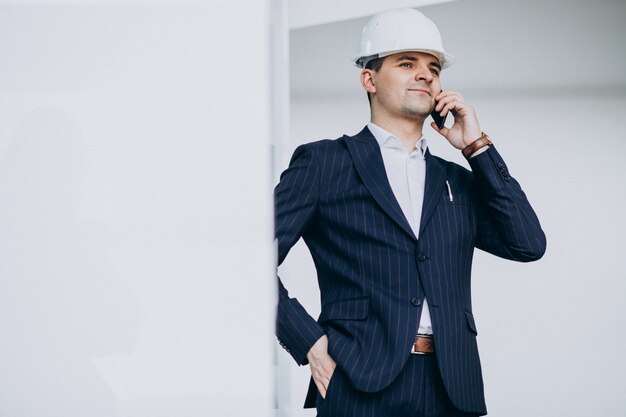 Knappe bedrijfsmenseningenieur in bouwvakker in een gebouw