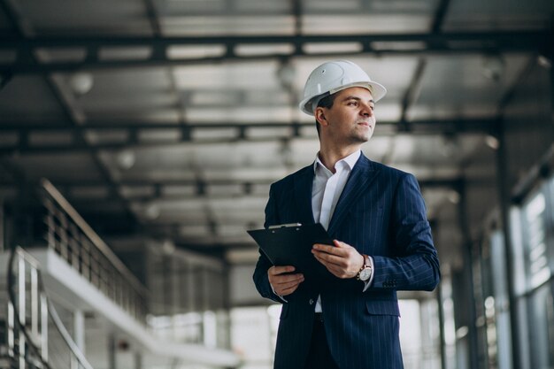 Knappe bedrijfsmenseningenieur in bouwvakker in een gebouw