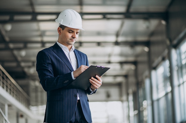 Knappe bedrijfsmenseningenieur in bouwvakker in een gebouw