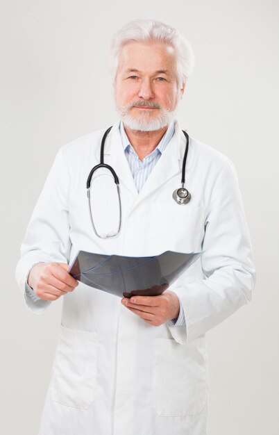 Knappe bejaarde arts met röntgenfoto