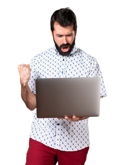 Knappe brunette man met baard met laptop