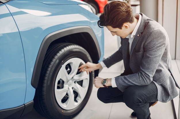 Knappe en elegante man in een autosalon