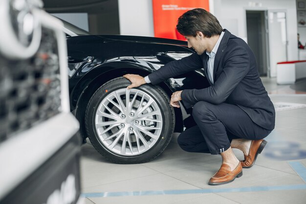 Knappe en elegante man in een autosalon