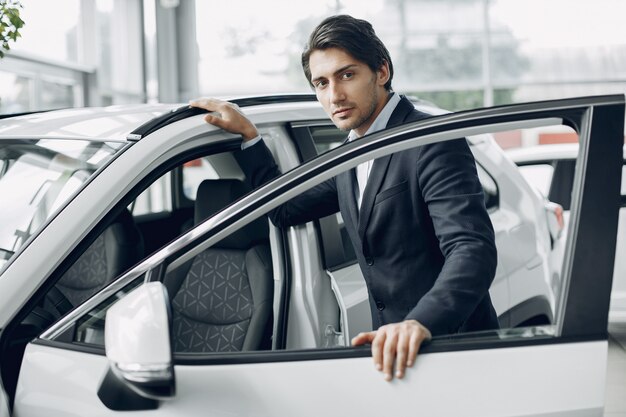 Knappe en elegante man in een autosalon