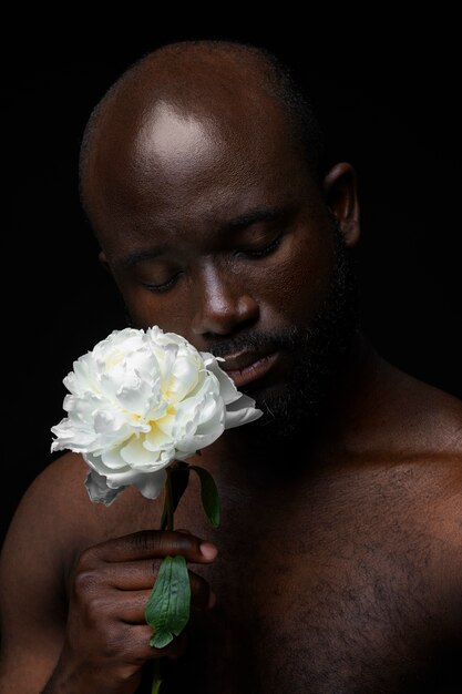 Gratis foto knappe en gevoelige man met bloem