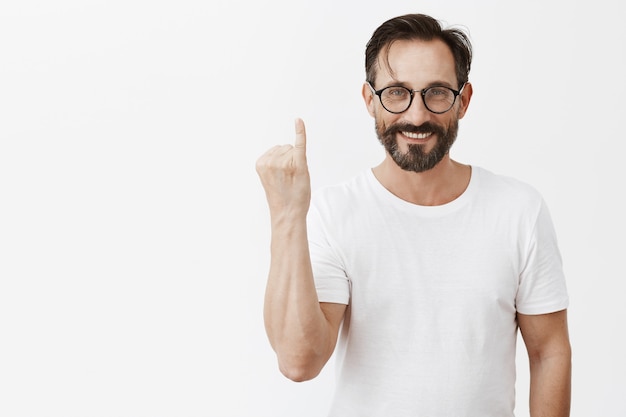 Knappe gelukkig bebaarde volwassen man met bril poseren