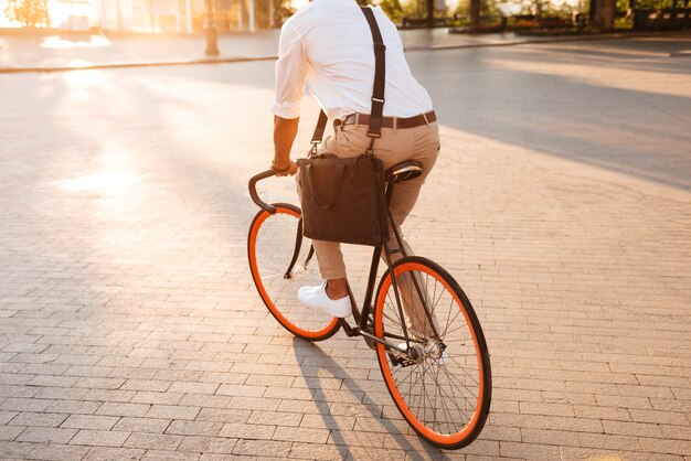 Knappe jonge Afrikaanse man vroege ochtend met fiets