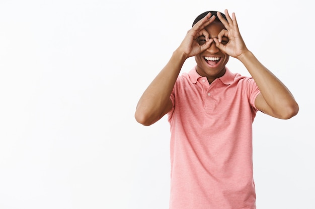 Knappe jonge afro-amerikaan met roze polot-shirt