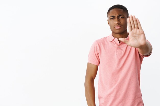 Knappe jonge Afro-Amerikaan met roze polot-shirt