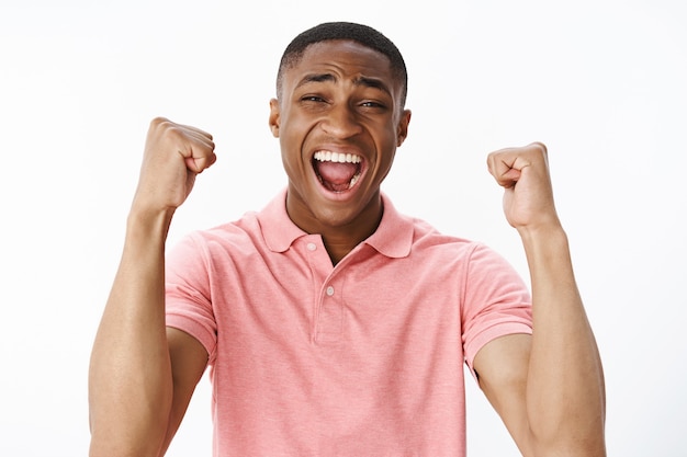Knappe jonge Afro-Amerikaan met roze polot-shirt