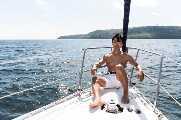 Knappe jonge man die van tijd op boot geniet