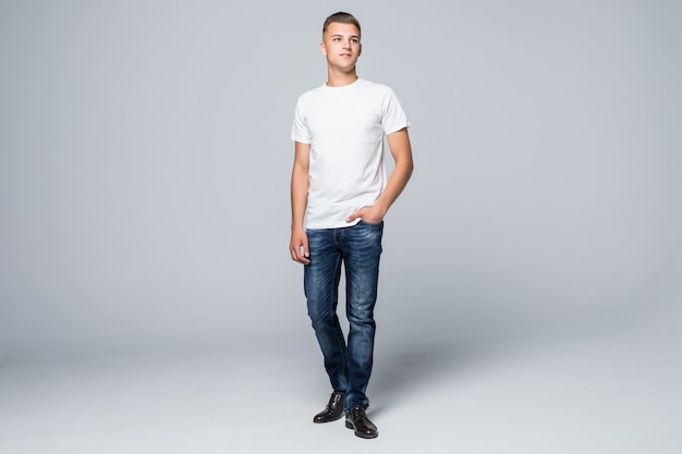 Knappe jonge man in een casual stijl kleding wit t-shirt en spijkerbroek op wit
